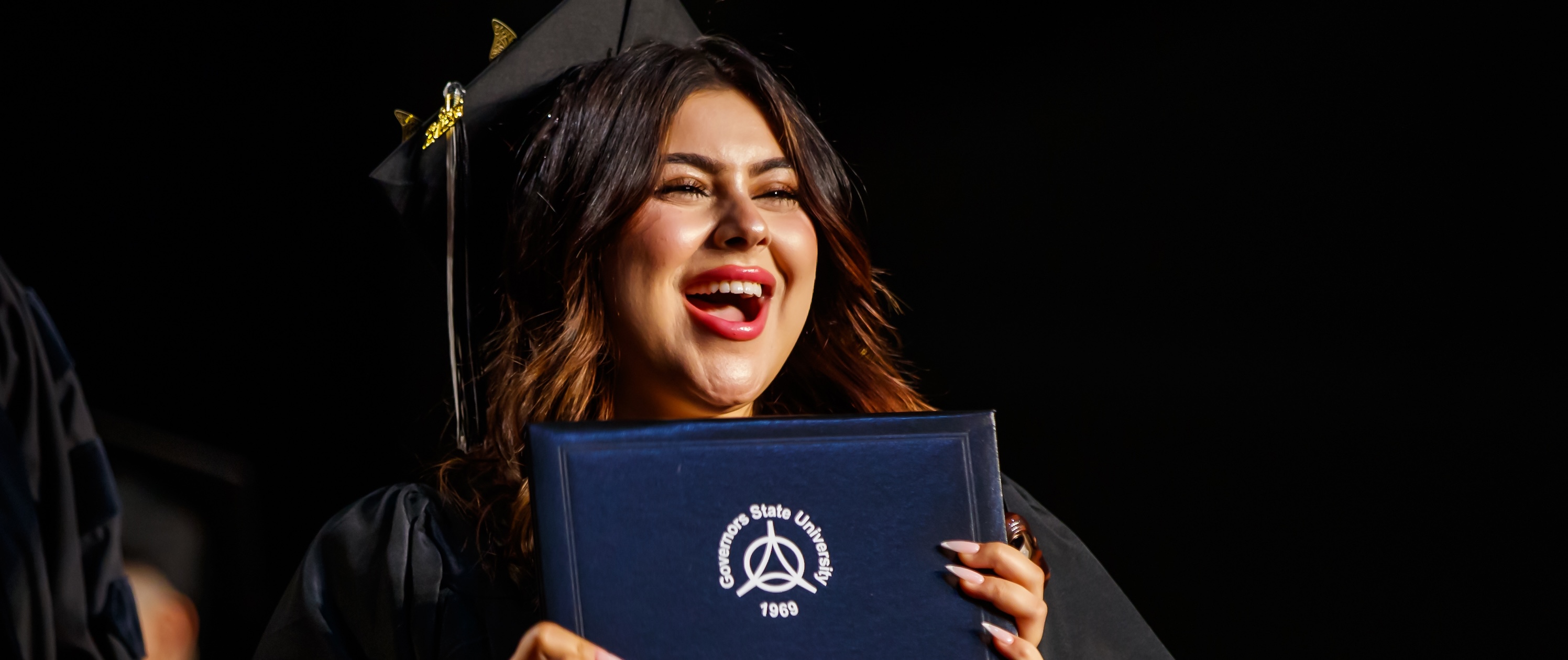 GovState graduate holding their diploma
